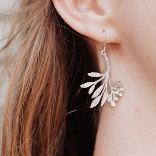 Shimmering silver earrings in botanical olive sprig design. 'Gossamer Daphne' ethical hand beaten stainless steel earrings by Nic Danning Jewellery.