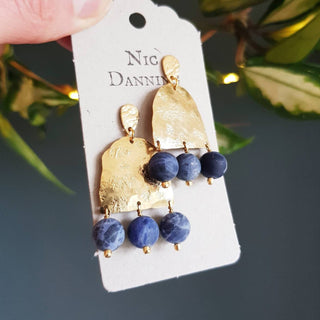 Glowing gold earrings with semi precious sodalite beadwork. 'Titans Astrape' ethical hand beaten brass earrings by Nic Danning Jewellery.