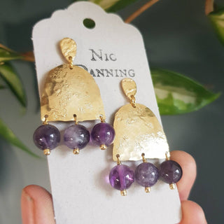 Glowing gold earrings with semi precious amethyst beadwork. 'Titans Leto' ethical hand beaten brass earrings by Nic Danning Jewellery.