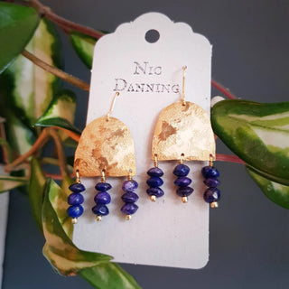Glowing gold earrings with semi precious lapis lazuli beadwork. 'Titans Olympus' ethical hand beaten brass earrings by Nic Danning Jewellery.