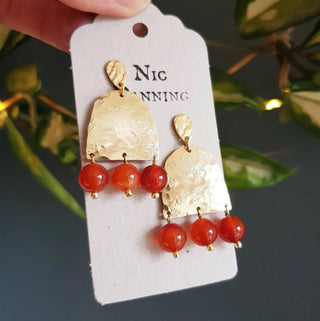 Glowing gold earrings with aqua coloured semi precious carnelian beadwork. 'Titans Hestia' ethical hand beaten brass earrings by Nic Danning Jewellery.