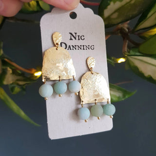 Glowing gold earrings with aqua coloured semi precious amazonite stones beadwork. 'Titans Theia' ethical hand beaten brass earrings by Nic Danning Jewellery.