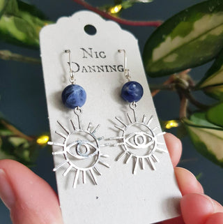 Charity fundraiser design to support the humanitarian crisis in Syria. Shimmering silver earrings with eye of protection design and sodalite beads. 'Himaya' ethical hand beaten stainless steel earrings by Nic Danning Jewellery.