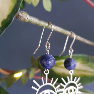Charity fundraiser design to support the humanitarian crisis in Syria. Shimmering silver earrings with eye of protection design and sodalite beads. 'Himaya' ethical hand beaten stainless steel earrings by Nic Danning Jewellery.