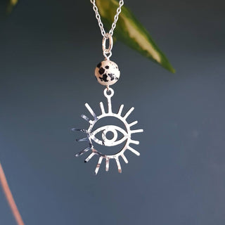 Charity fundraiser design to support the humanitarian crisis in Syria. Shimmering silver necklace with eye of protection design and spotted jasper bead. 'Himaya' ethical hand beaten stainless steel necklace by Nic Danning Jewellery.