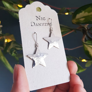 Shimmering silver earrings in dainty star design. 'Tempest Stella' ethical hand beaten stainless steel earrings by Nic Danning Jewellery.
