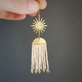 Glowing gold celestial earrings with fine Japanese glass beads in Ivory Pearl. 'Hera Oracle' gold plated brass and hand beaded earrings by Nic Danning Jewellery.