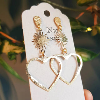 Glowing gold stud earrings in statement heart and sunstar design. 'The Lovers, Miranda' ethical hand beaten brass earrings by Nic Danning Jewellery.