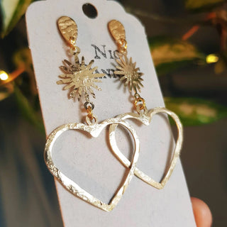 Glowing gold stud earrings in statement heart and sunstar design. 'The Lovers, Miranda' ethical hand beaten brass earrings by Nic Danning Jewellery.