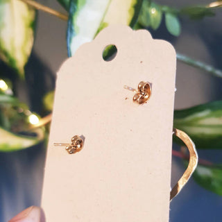 Glowing gold earrings in statement cutout heart design. 'The Lovers, Portia' ethical hand beaten brass earrings by Nic Danning Jewellery.