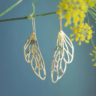 Glowing gold earrings in cutout dragonfly wing design. 'Gossamer Dryad' ethical hand beaten brass earrings by Nic Danning Jewellery.
