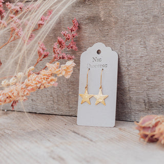 Glowing gold earrings in dainty star design. 'Tempest Stella' ethical hand beaten brass earrings by Nic Danning Jewellery.