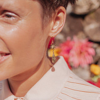 Glowing gold earrings in sunstar and drop design. 'Tempest Aurora' ethical hand beaten brass earrings by Nic Danning Jewellery.