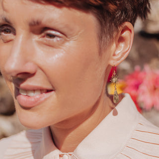 Glowing gold earrings in sunstar and drop design. 'Tempest Aurora' ethical hand beaten brass earrings by Nic Danning Jewellery.