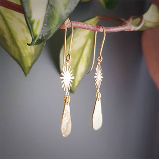 Glowing gold earrings in sunstar and drop design. 'Tempest Aurora' ethical hand beaten brass earrings by Nic Danning Jewellery.