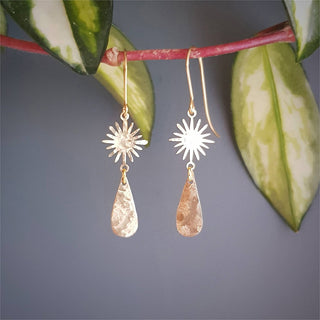 Glowing gold earrings in sunstar and drop design. 'Tempest Aurora' ethical hand beaten brass earrings by Nic Danning Jewellery.