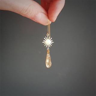 Glowing gold earrings in sunstar and drop design. 'Tempest Aurora' ethical hand beaten brass earrings by Nic Danning Jewellery.