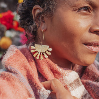 Glowing gold earrings in abstract floral design. 'Tempest Calendula' ethical hand beaten brass earrings by Nic Danning Jewellery.
