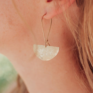 Glowing gold drop earrings in half moon design. 'Tempest Eclipse' ethical hand beaten brass earrings by Nic Danning Jewellery.