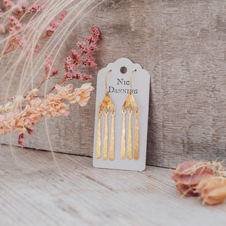 Glowing gold earrings in abstract geometric design. 'Tempest Imbrem' ethical hand beaten brass earrings by Nic Danning Jewellery.