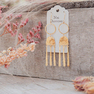 Glowing gold earrings in abstract geometric design. 'Tempest Nimbus' ethical hand beaten brass earrings by Nic Danning Jewellery.