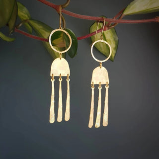 Glowing gold earrings in abstract geometric design. 'Tempest Nimbus' ethical hand beaten brass earrings by Nic Danning Jewellery.