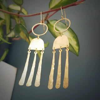 Glowing gold earrings in abstract geometric design. 'Tempest Nimbus' ethical hand beaten brass earrings by Nic Danning Jewellery.
