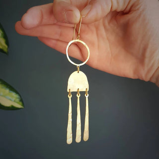 Glowing gold earrings in abstract geometric design. 'Tempest Nimbus' ethical hand beaten brass earrings by Nic Danning Jewellery.