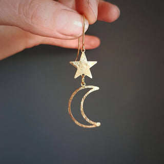 Glowing gold earrings in cascading celestial design. 'Tempest Noctis' ethical hand beaten brass earrings by Nic Danning Jewellery.