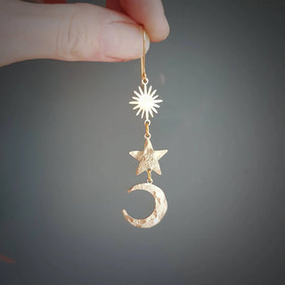Glowing gold earrings in cascading celestial design. 'Tempest Twilight' ethical hand beaten brass earrings by Nic Danning Jewellery.