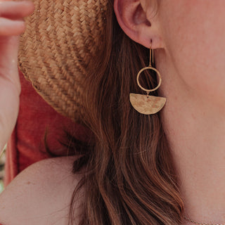Glowing gold earrings in an abstract geometric design. 'Tempest Umbra' ethical hand beaten brass earrings by Nic Danning Jewellery.