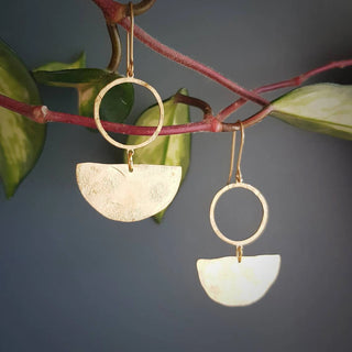 Glowing gold earrings in an abstract geometric design. 'Tempest Umbra' ethical hand beaten brass earrings by Nic Danning Jewellery.