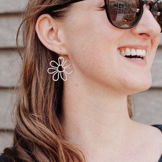 Shimmering silver earrings in cutout floral design. 'Gossamer Chloris' ethical hand beaten stainless steel earrings by Nic Danning Jewellery.