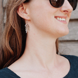 Shimmering silver earrings in botanical leaf design. 'Gossamer Athena' ethical hand beaten stainless steel earrings by Nic Danning Jewellery.
