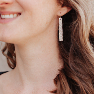 Shimmering silver earrings in botanical bar design. 'Gossamer Ceres' ethical hand beaten stainless steel earrings by Nic Danning Jewellery.