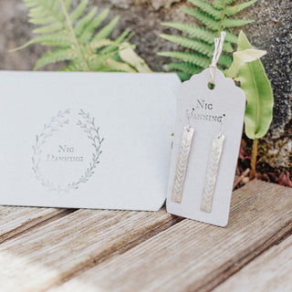 Shimmering silver earrings in botanical bar design. 'Gossamer Ceres' ethical hand beaten stainless steel earrings by Nic Danning Jewellery.