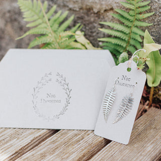 Shimmering silver earrings in botanical fern leaf design. 'Gossamer Fern' ethical hand beaten stainless steel earrings by Nic Danning Jewellery.