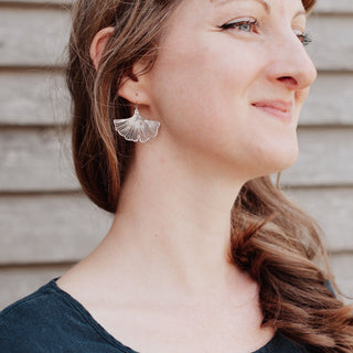 Shimmering silver earrings in botanical ginkgo leaf design. 'Gossamer Ginkgo' ethical hand beaten stainless steel earrings by Nic Danning Jewellery.