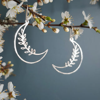 Shimmering silver earrings in botanical crescent moon design. 'Gossamer Selene' ethical hand beaten stainless steel earrings by Nic Danning Jewellery.