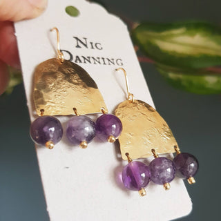 Glowing gold earrings with semi precious amethyst beadwork. 'Titans Leto' ethical hand beaten brass earrings by Nic Danning Jewellery.