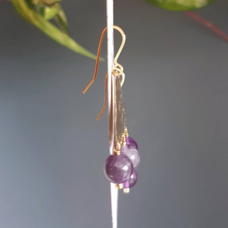 Glowing gold earrings with semi precious amethyst beadwork. 'Titans Leto' ethical hand beaten brass earrings by Nic Danning Jewellery.