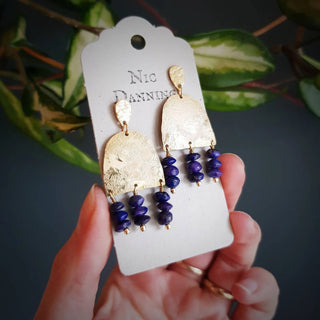 Glowing gold earrings with semi precious lapis lazuli beadwork. 'Titans Olympus' ethical hand beaten brass earrings by Nic Danning Jewellery.