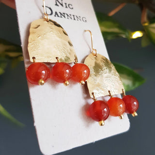 Glowing gold earrings with aqua coloured semi precious carnelian beadwork. 'Titans Hestia' ethical hand beaten brass earrings by Nic Danning Jewellery.