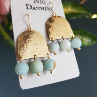 Glowing gold earrings with aqua coloured semi precious amazonite stones beadwork. 'Titans Theia' ethical hand beaten brass earrings by Nic Danning Jewellery.